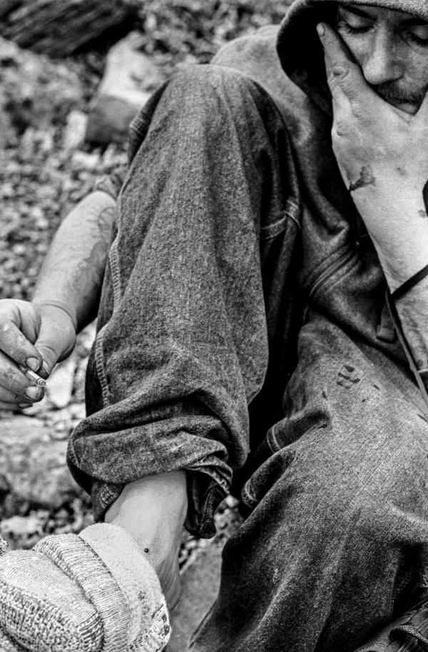 Jay finds success injecting into his foot. He starts to fall back as the warm opiate embrace overtakes his body.