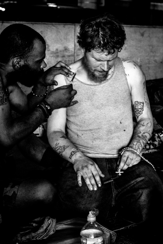Greg helps Jason inject heroin into his neck.