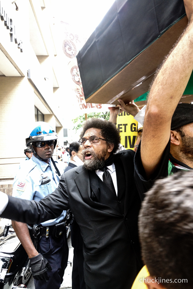 Cornel West helping to stack makeshift coffins outside the offices of the Washington Post.
