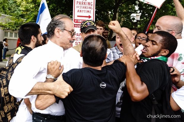Palestinian supporters restrain a fellow demonstrator after a pro-Israeli demonstrator lunged, and kicked into the crowd. 