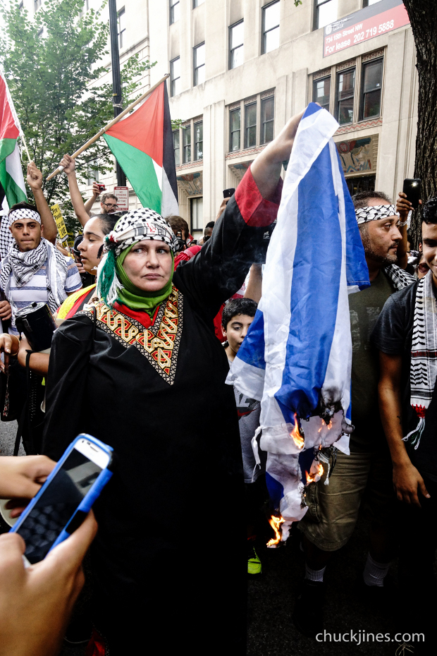 Pro-Palestinian protester marches with a burning Israeli flag during a demonstration against violence in the Gaza strip, August 2, 2014.