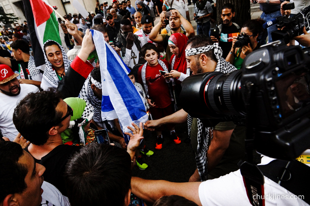 Pro-Palestinian protesters burn an Israeli flag during a demonstration against violence in the Gaza strip, August 2, 2014.