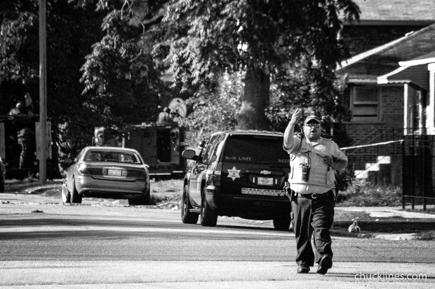 HARVEY IL - AUGUST 20, 2014: A Police officer yells "Get the fuck out of here" to journalists standing in anon-restricted area along 146th and Seeley during a hostage standoff in Harvey, IL on August 20, 2014  
