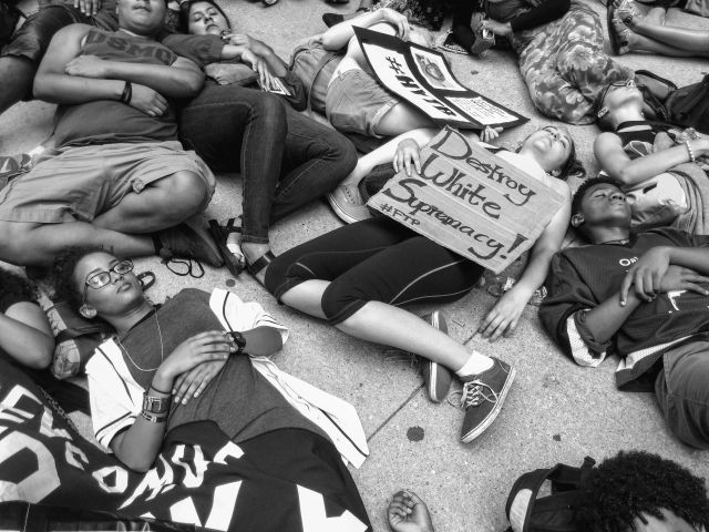 CHICAGO, IL. Aug. 17, 2015 - #BlackLivesMatters activists fall onto the sidewalk outside Chicago's City Hall during a moment of remembrance for the recent alleged unjustified killings of blacks by police officers. This political action was hosted by Stop Mass Incarceration Network Chicago.