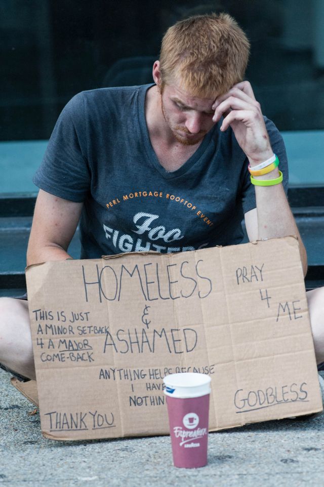 CHICAGO, IL. Sep 6, 2015 - Caleb Higgins, age 26, panhandles on Chicago's Michigan Ave. in an attempt to gather the funds to buy enough heroin to stave off being dope sick for a few more hours.