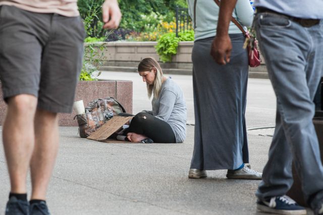 CHICAGO, IL. Sep 6, 2015 - Mandrell White, age 34, panhandles with her cardboard sign on Chicago's Michigan Ave. in an attempt to raise money to buy enough heroin to hold off withdraws for a few more hours.