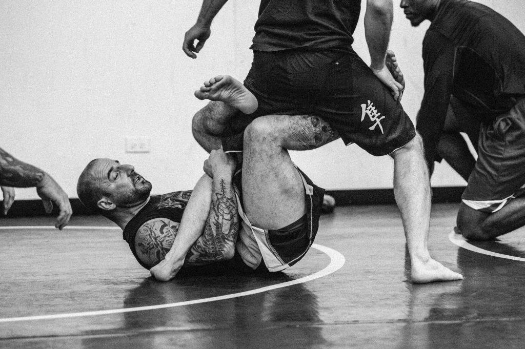 Angelo Amato (ground) works with Tyler Lorek on his grappling skills.