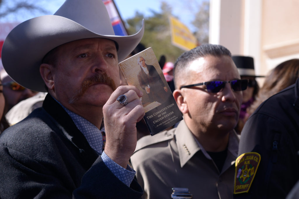 Santa Fe,New Mexico/USA - January 31, 2020 – A Second Amendment supporter holds up acopy of the United States Constitution outside the state Capital Building inSanta Fe, New Mexico, on Friday, January 31, 2020, in a show of opposition to theproposed “red flag” legislation that is now before New Mexico lawmakers.  